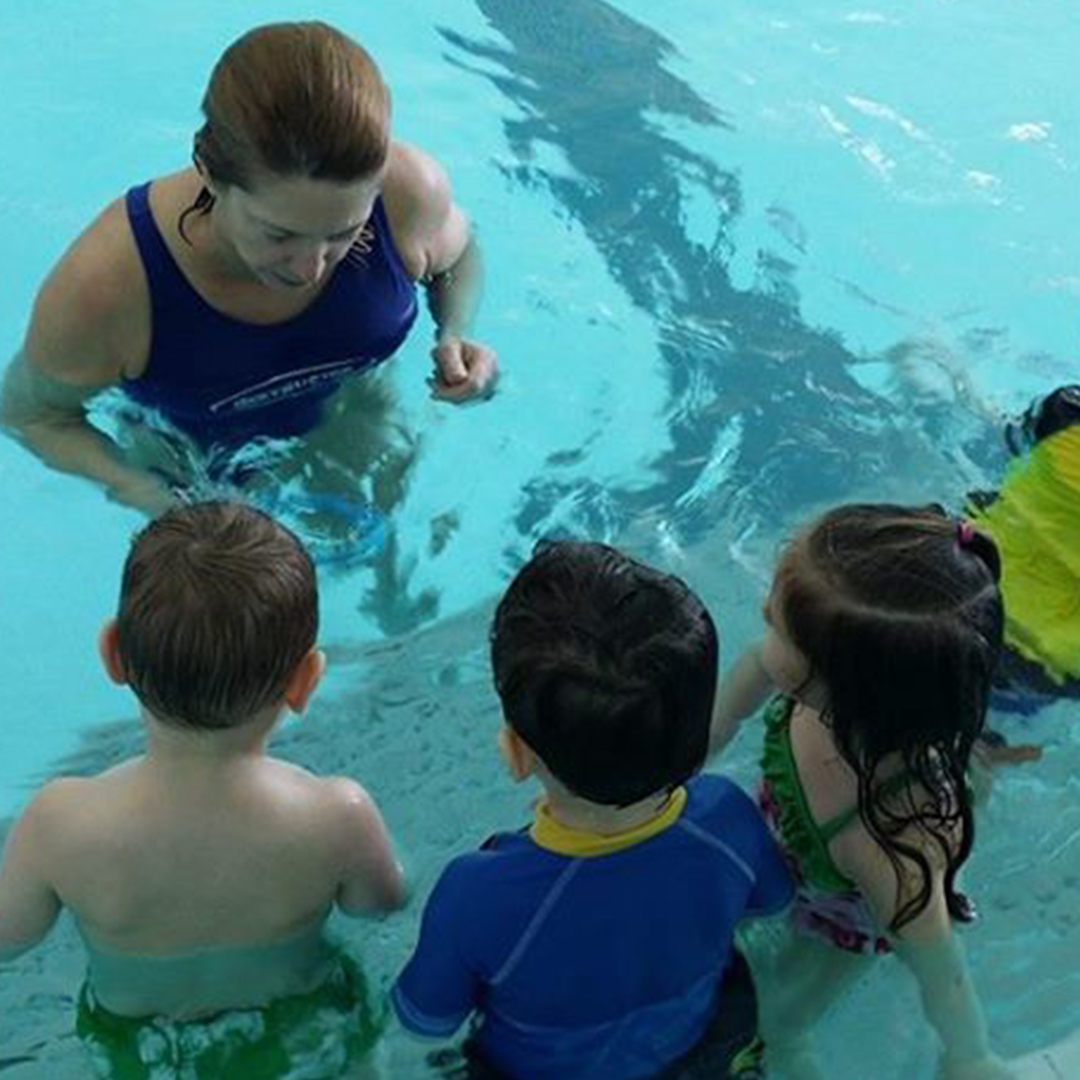 Instructor with group of preschool swimmers in the water