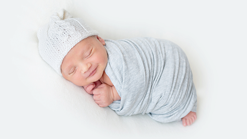 Photo of a swaddled, sleeping infant