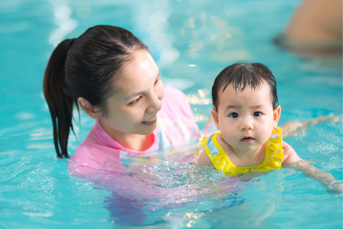 Mother safely swimming with her infant