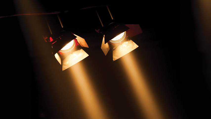 Photo of stage lights pointing to the stage