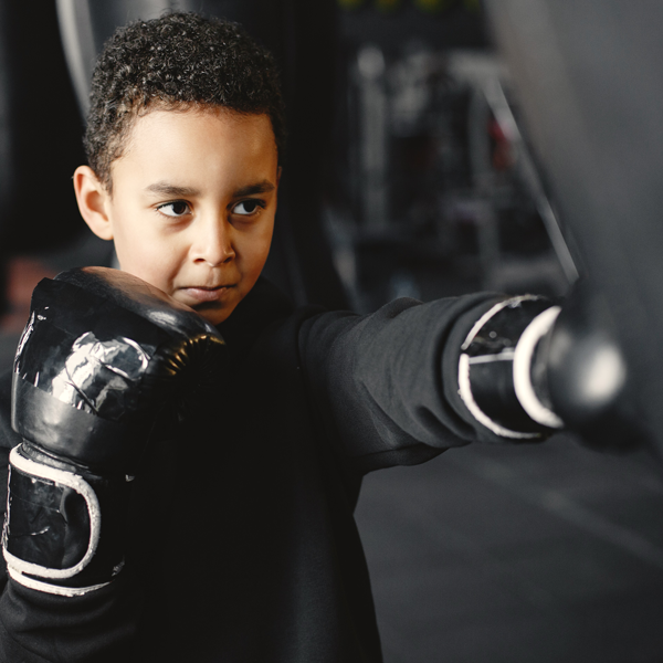 Boy hitting boxing bag