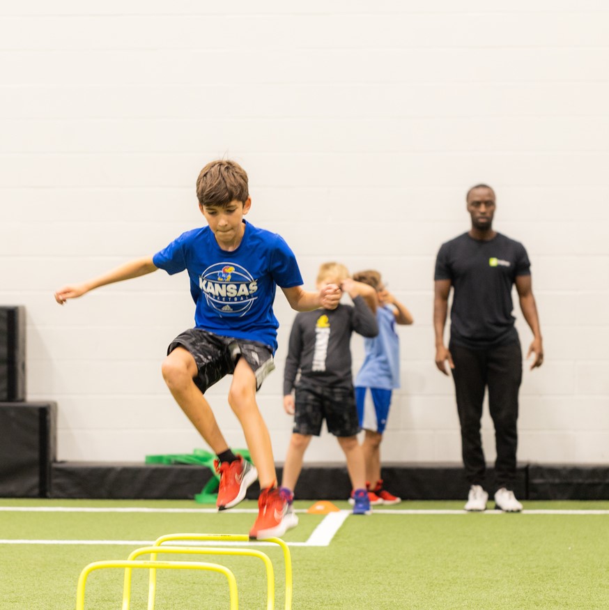 Boy jumping over hurdles