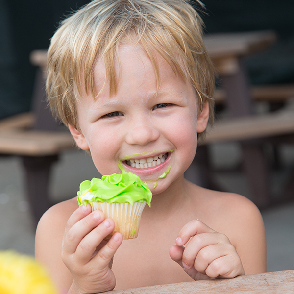 Boy eating a cupcake with neon green frosting