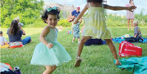 Toddlers jumping up and down outside listening to music