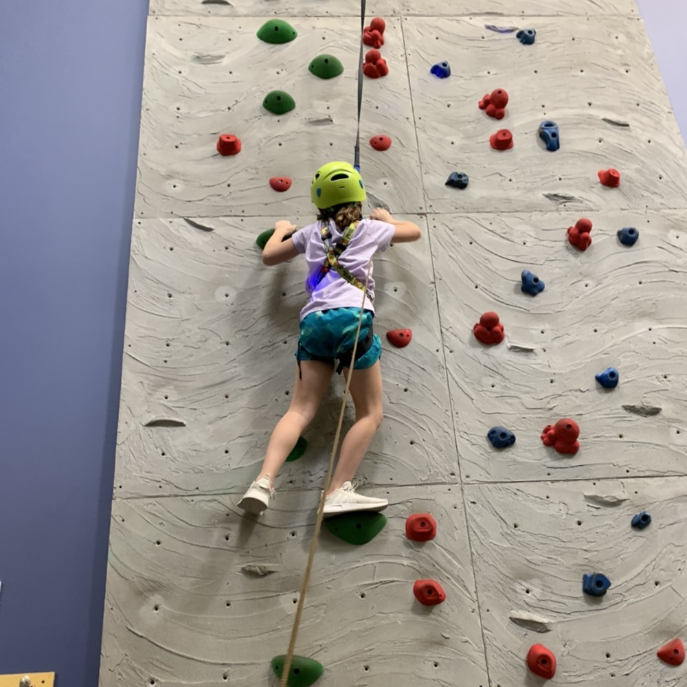 Girl climbing rock wall in the J Clubhouse