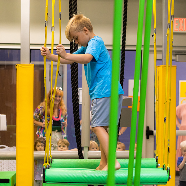 Boy doing kid's ninja warrior course