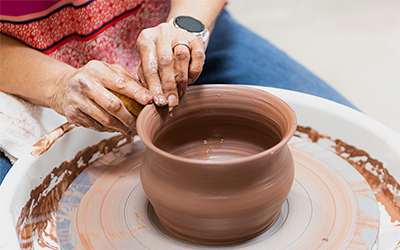 Woman forming a bowl on a potter's wheel