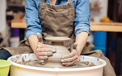 Photo person shaping clay on a wheel