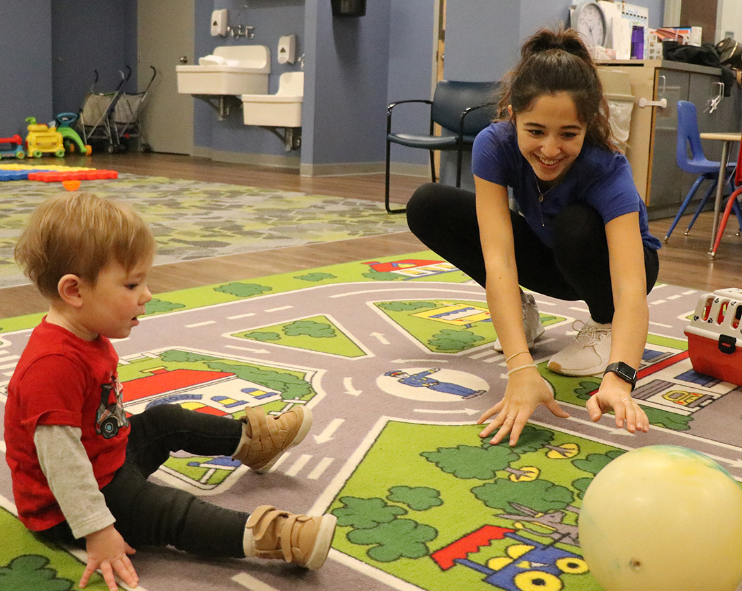 Clubhouse staff play with a toddler
