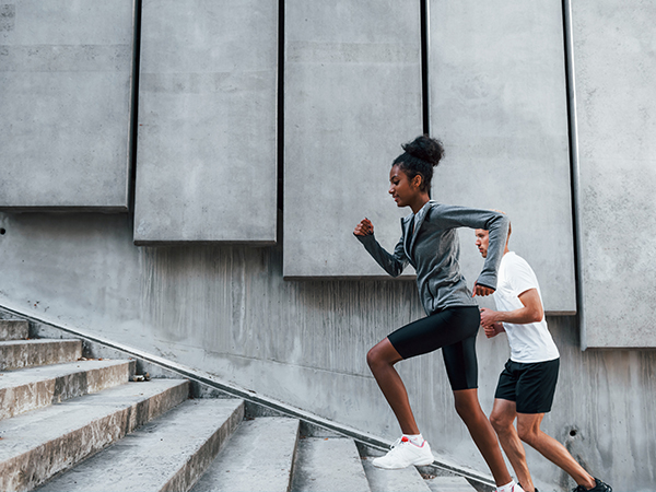 Man meditating and a woman doing a lunge