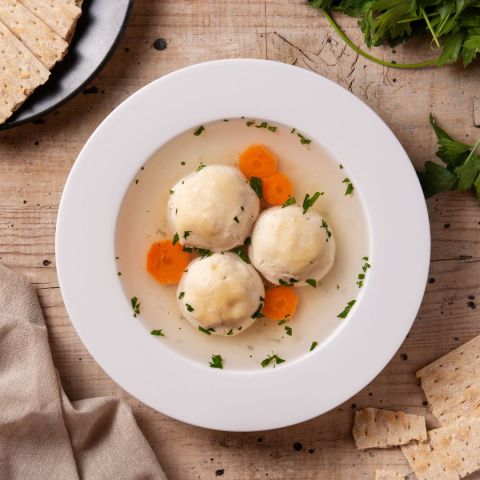 Matzah ball soup in white bowl