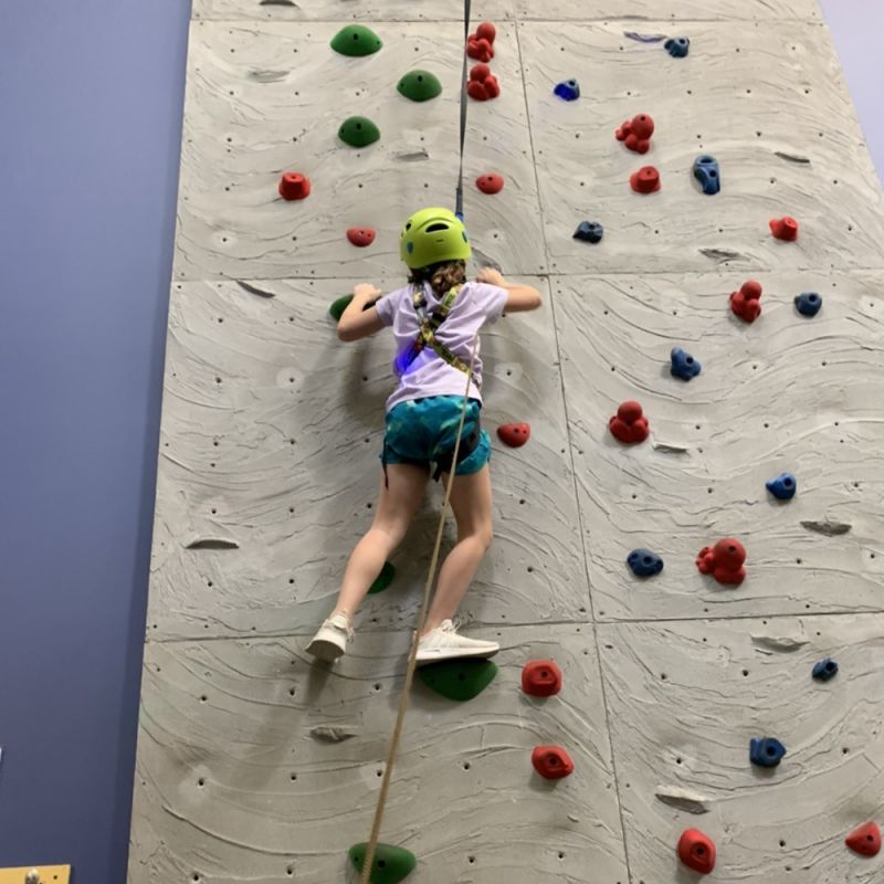 Girl climbing rock wall in Big J Clubhouse