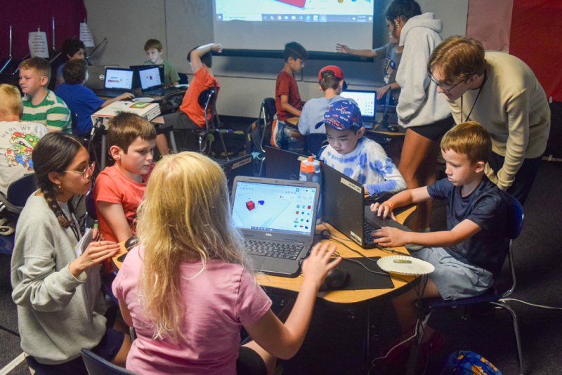 Three boys working on computers