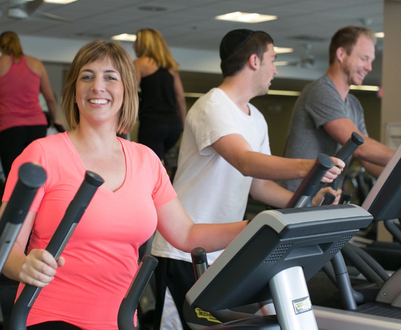 Woman smiling on elliptical in our fitness center