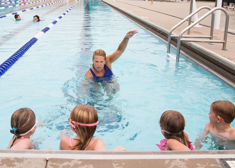 Instructor showing students a swim stroke
