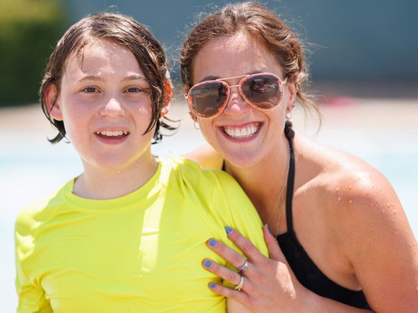 Mom and son smiling at The J's member pool party
