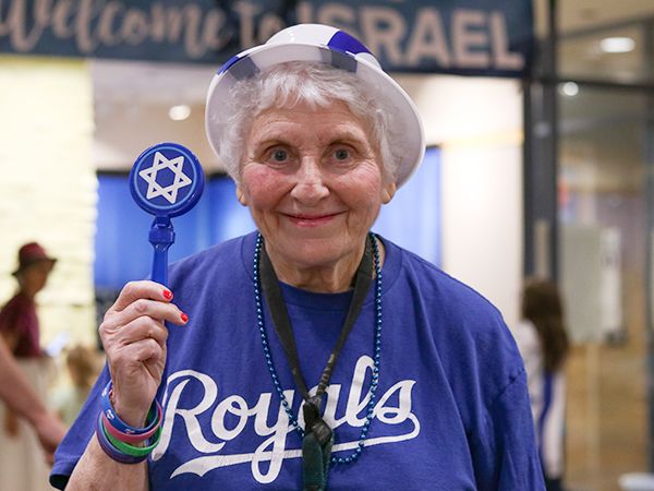 Woman in white and blue t-shirt holding the Star of David