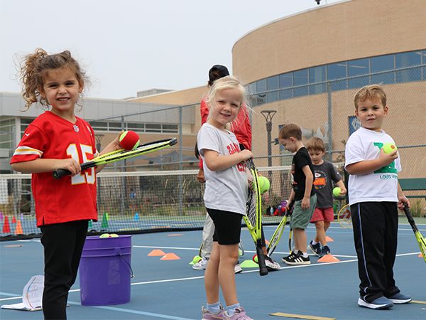 Kids with tennis racquets and balls