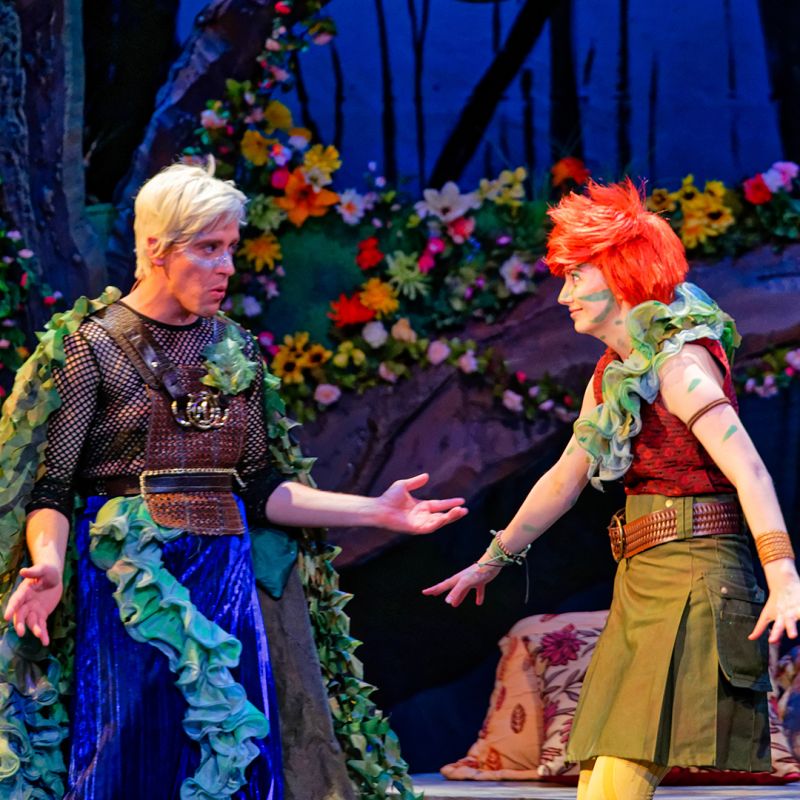 Scene from A Midsummer Night's Dream with vibrant blue and orange costumes