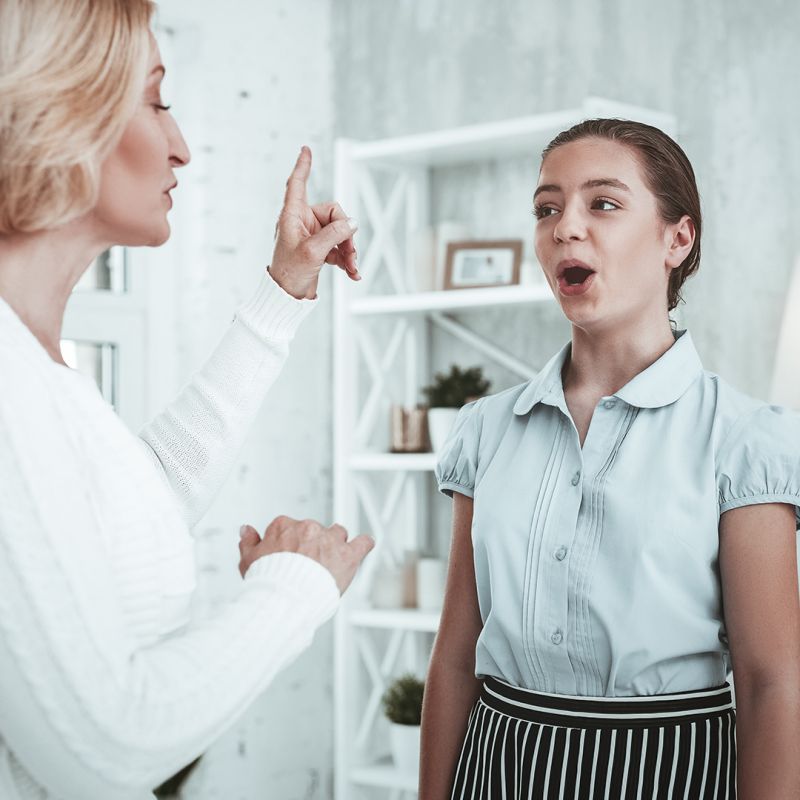 Teacher instructs girl to increase her voice pitch.